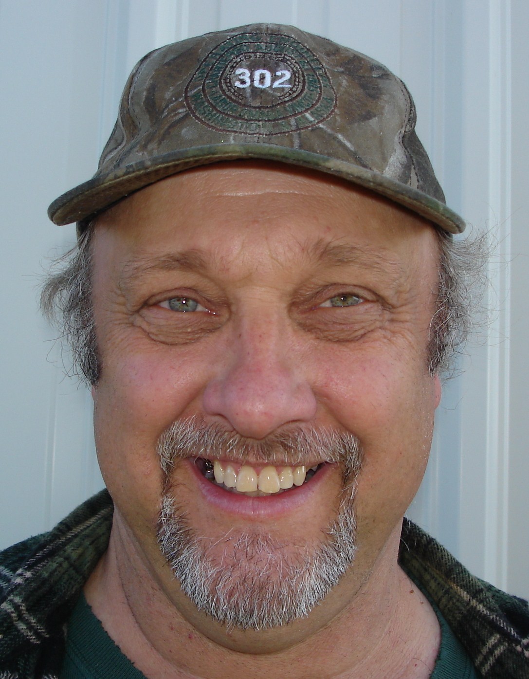 a man wearing a hat and smiling at the camera