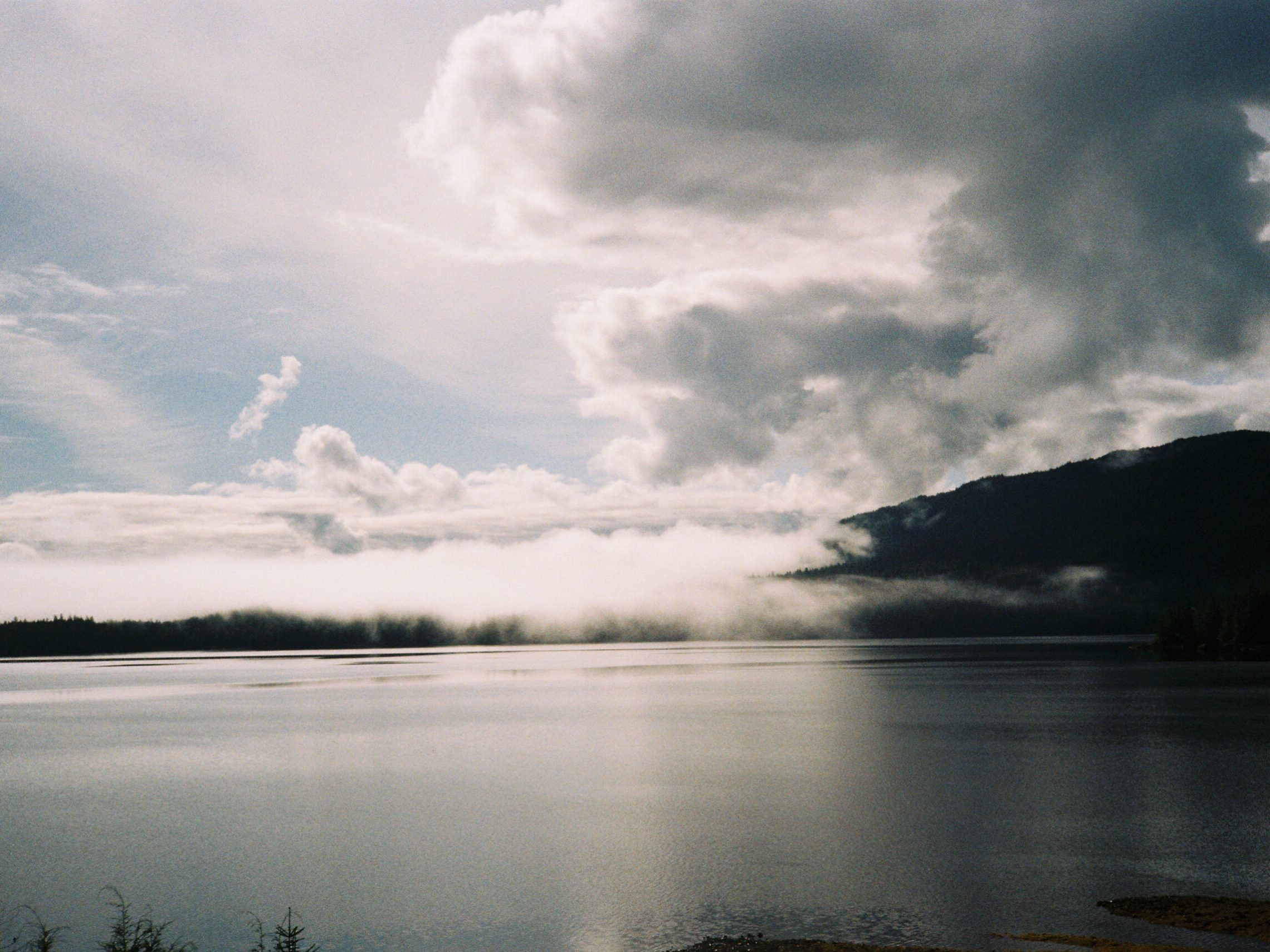 a group of clouds in the sky over a body of water