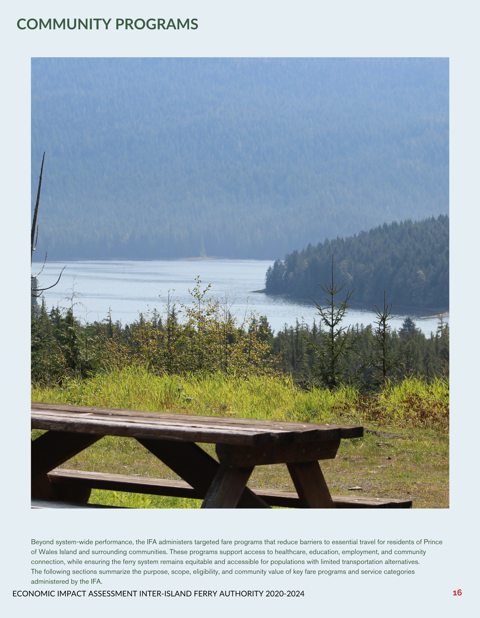 Wooden picnic table overlooking a scenic lake and forest landscape.