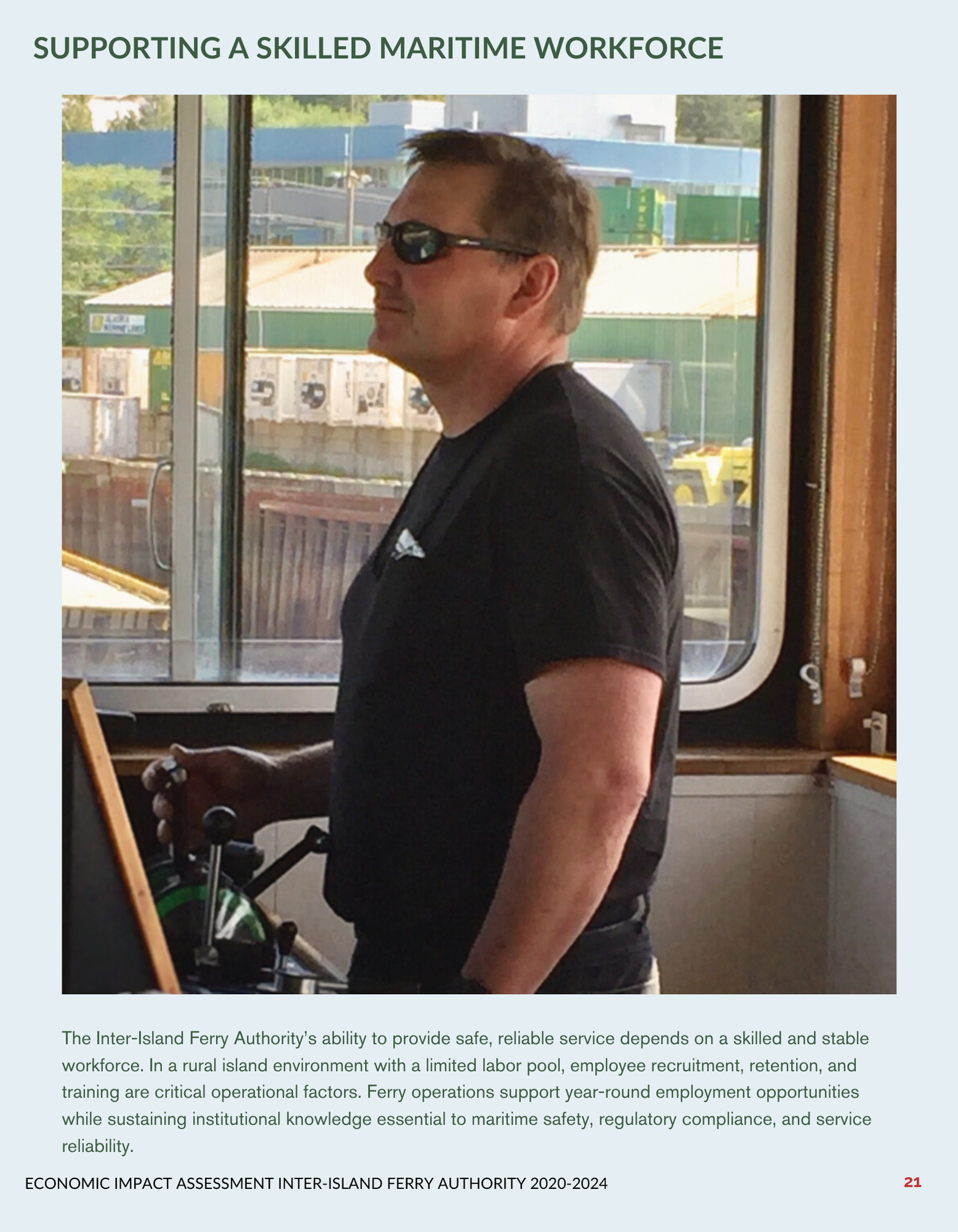 Person in sunglasses steering a boat, with industrial buildings visible through the window.